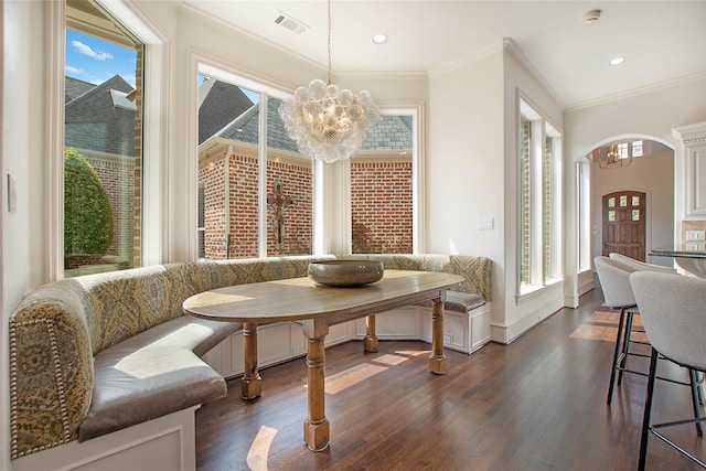 dining space featuring visible vents, dark wood finished floors, breakfast area, ornamental molding, and an inviting chandelier