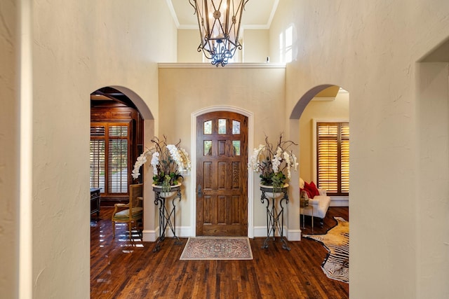 entrance foyer featuring wood-type flooring, a high ceiling, and ornamental molding