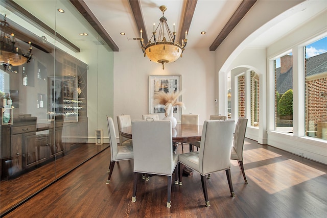 dining room featuring beamed ceiling, plenty of natural light, and wood finished floors