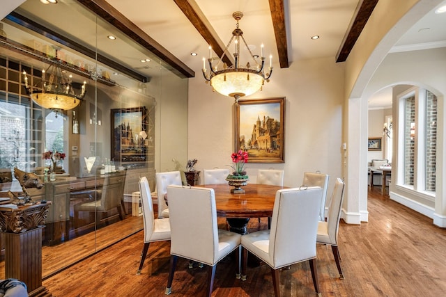 dining area with hardwood / wood-style flooring, beam ceiling, and crown molding