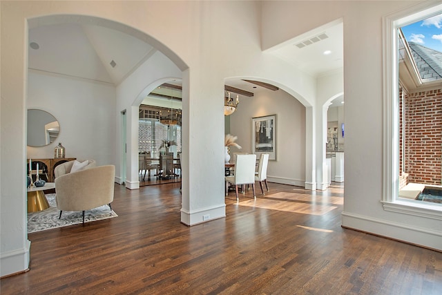 foyer entrance featuring visible vents, a high ceiling, baseboards, and wood finished floors