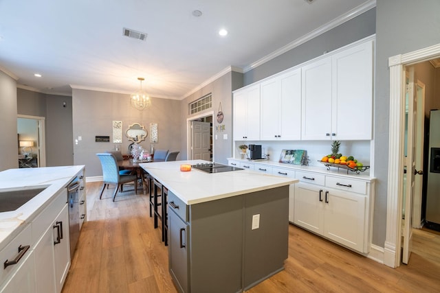 kitchen with decorative light fixtures, white cabinets, and a center island