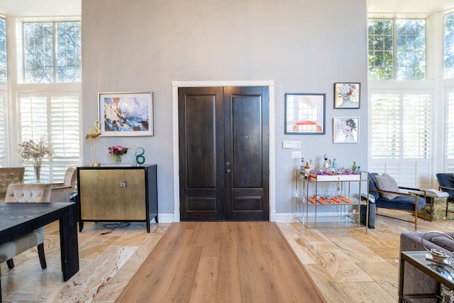 foyer entrance featuring light hardwood / wood-style floors and a towering ceiling