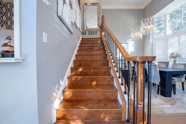 stairs featuring a towering ceiling and an inviting chandelier