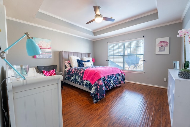 bedroom featuring ceiling fan, dark wood-type flooring, and a tray ceiling