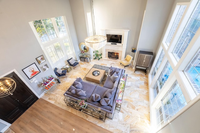 living room featuring a towering ceiling, hardwood / wood-style floors, and a notable chandelier