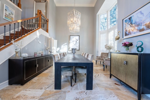 dining area featuring an inviting chandelier, crown molding, and a high ceiling