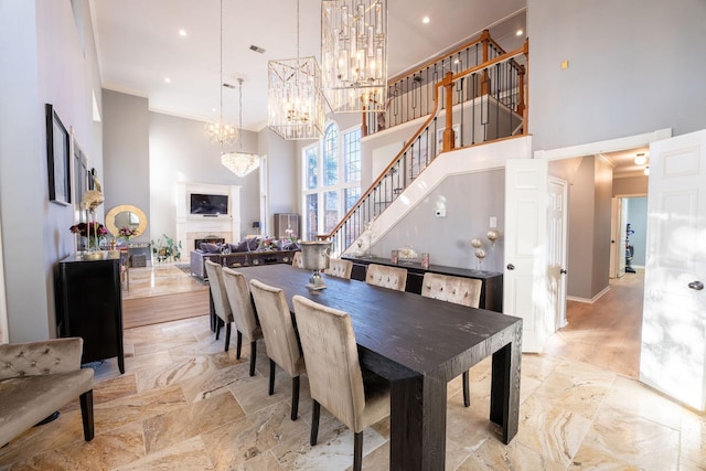 dining room featuring crown molding, a high ceiling, and a notable chandelier