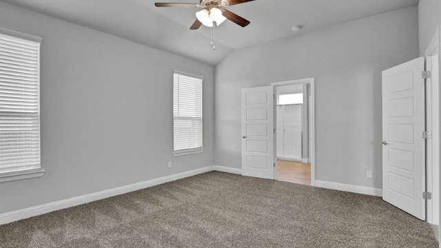 unfurnished bedroom with ceiling fan, ensuite bathroom, carpet flooring, and vaulted ceiling