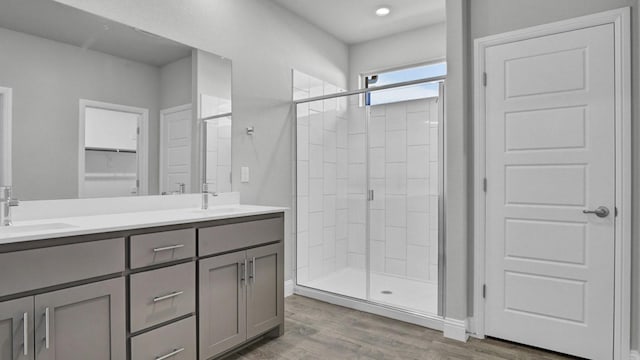 bathroom featuring a shower with shower door, vanity, and hardwood / wood-style flooring