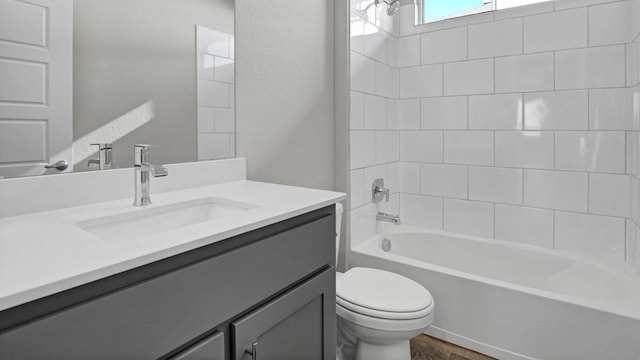 full bathroom featuring toilet, tiled shower / bath, hardwood / wood-style floors, and vanity