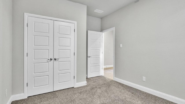 unfurnished bedroom with light carpet and a closet