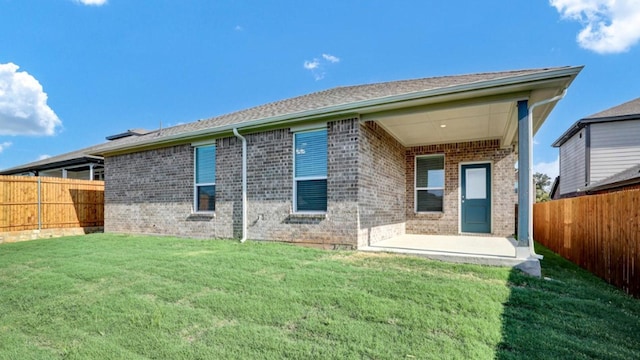 rear view of property with a patio and a yard