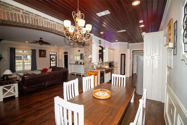 dining space with ceiling fan with notable chandelier, sink, dark hardwood / wood-style flooring, and crown molding