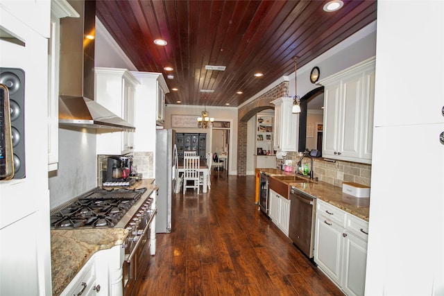 kitchen with white cabinetry, wooden ceiling, stainless steel appliances, decorative light fixtures, and wall chimney exhaust hood