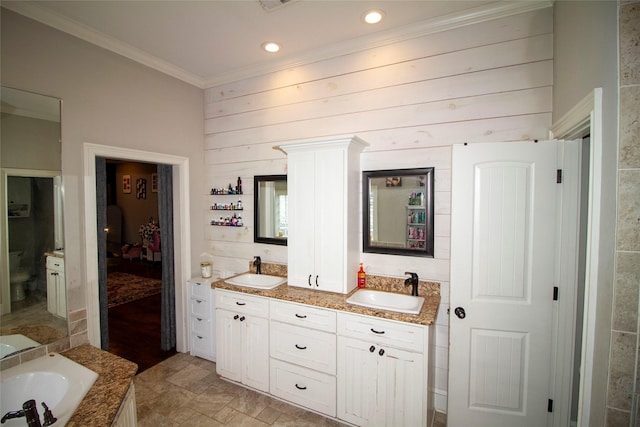 bathroom with vanity, a tub, wood walls, and ornamental molding