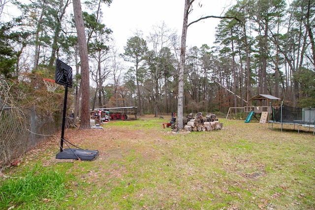 view of yard with a trampoline and a playground