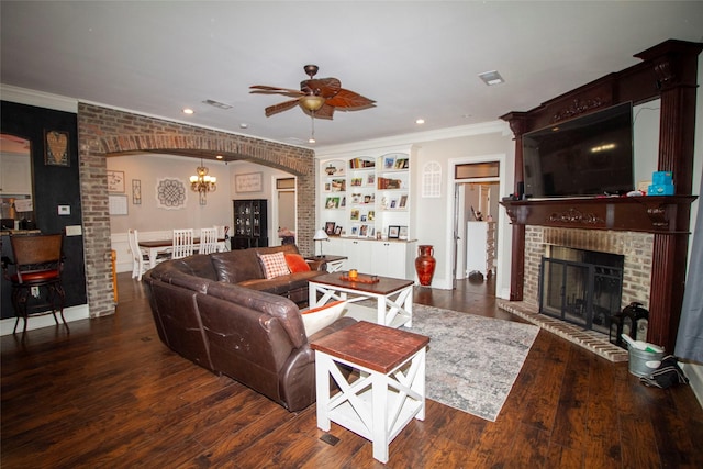 living room featuring brick wall, ceiling fan, dark hardwood / wood-style floors, a brick fireplace, and crown molding