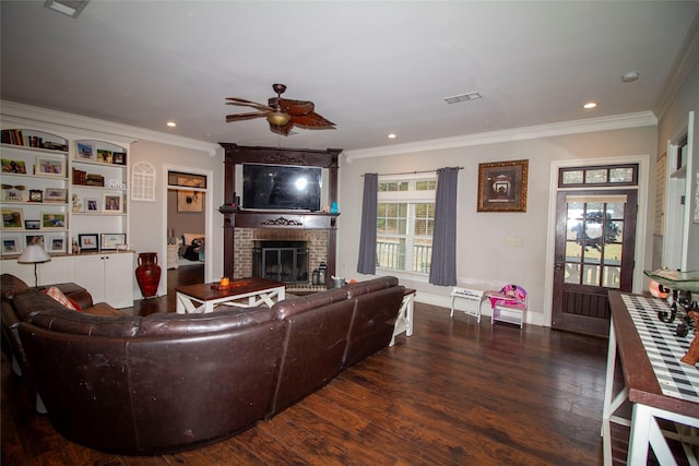 living room with ceiling fan, dark hardwood / wood-style floors, ornamental molding, and a brick fireplace