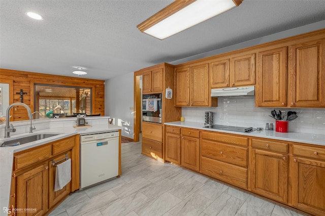 kitchen featuring dishwasher, tasteful backsplash, sink, oven, and black electric cooktop