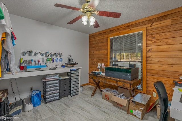 office featuring ceiling fan, wooden walls, and a textured ceiling