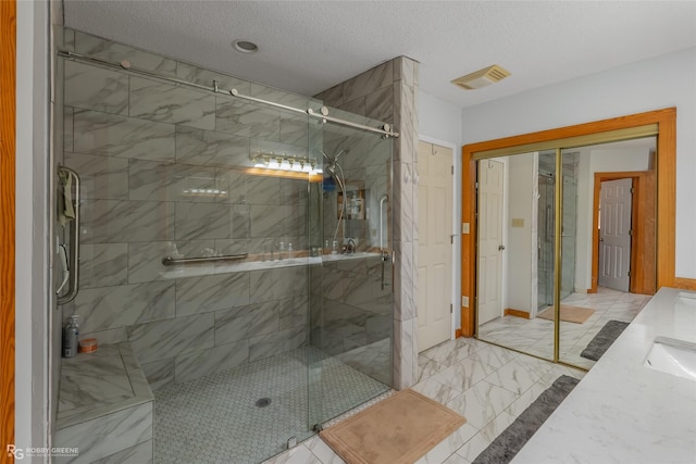 bathroom with vanity, a textured ceiling, and an enclosed shower