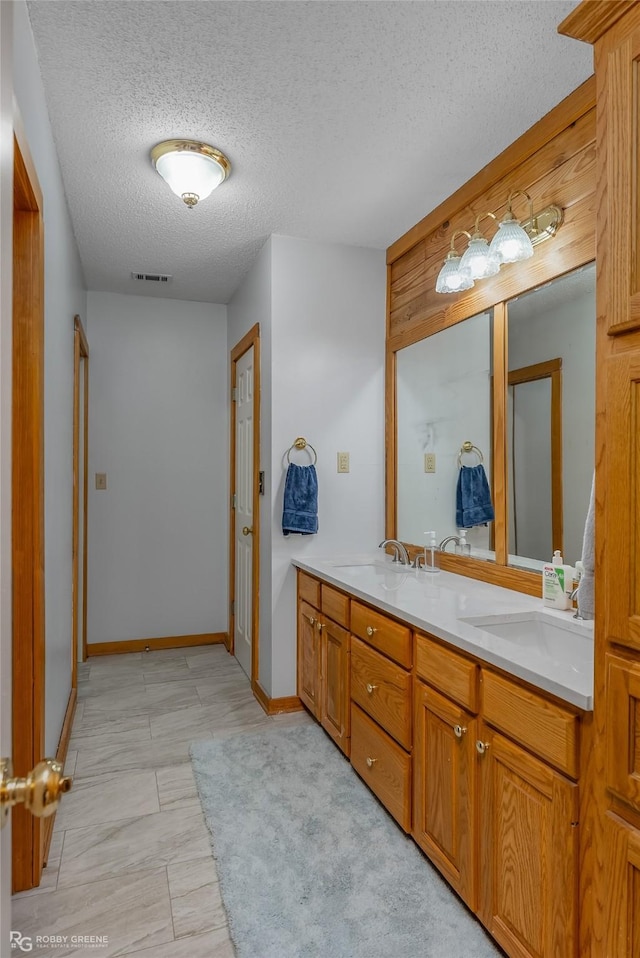 bathroom with a textured ceiling and vanity