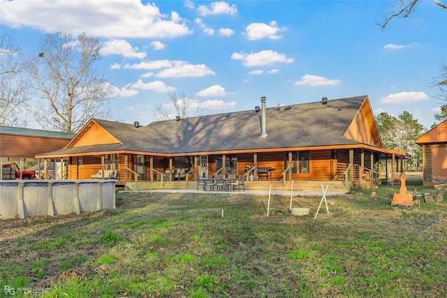 rear view of property featuring a patio area and a lawn