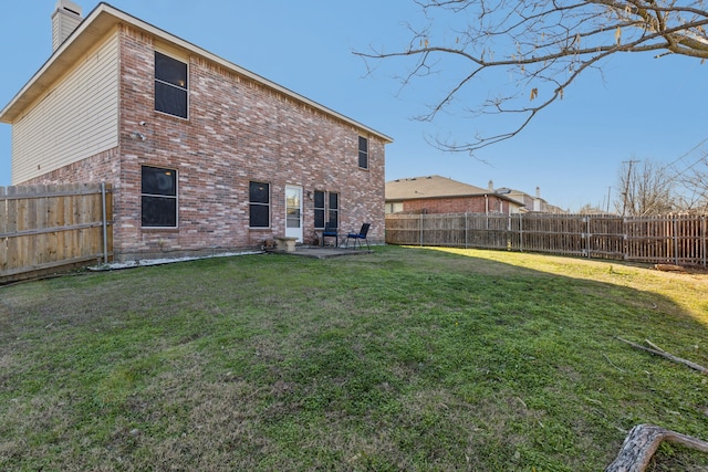 back of property with a yard and a patio