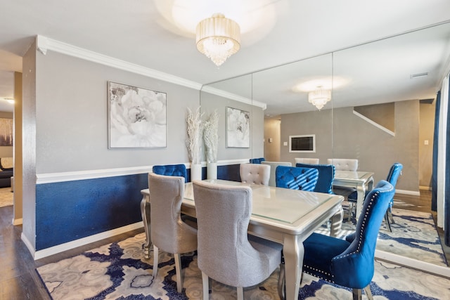 dining space with crown molding, a chandelier, and hardwood / wood-style flooring