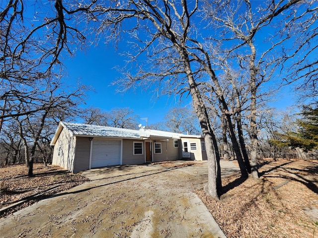 view of front of home with a garage, driveway, and metal roof