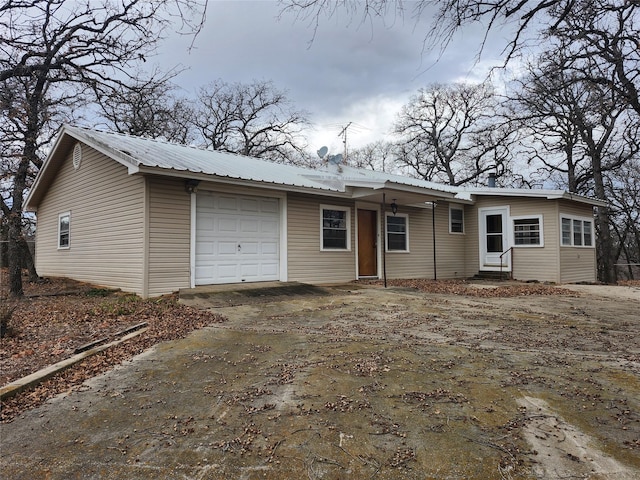 view of front of property with a garage, driveway, and metal roof