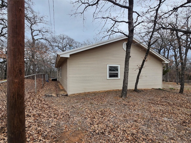 view of side of home featuring fence