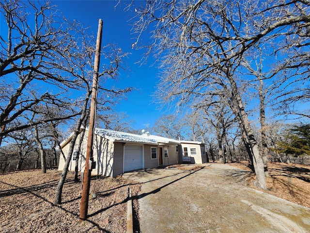 view of front of house with a garage, driveway, and metal roof