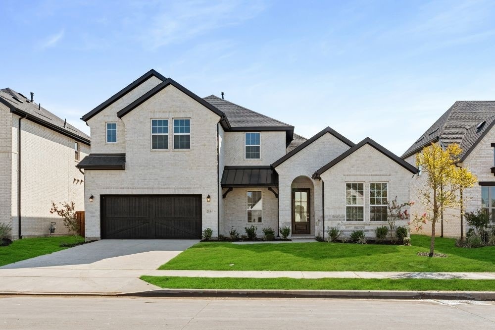 view of front of home with a front lawn and a garage