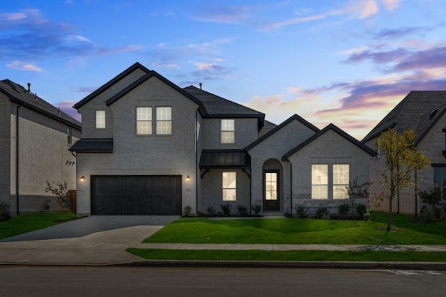 view of front of home with a garage and a yard