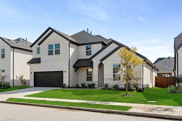 view of front of property featuring a front yard and a garage