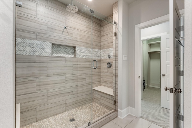 bathroom with tile patterned floors and a shower with door