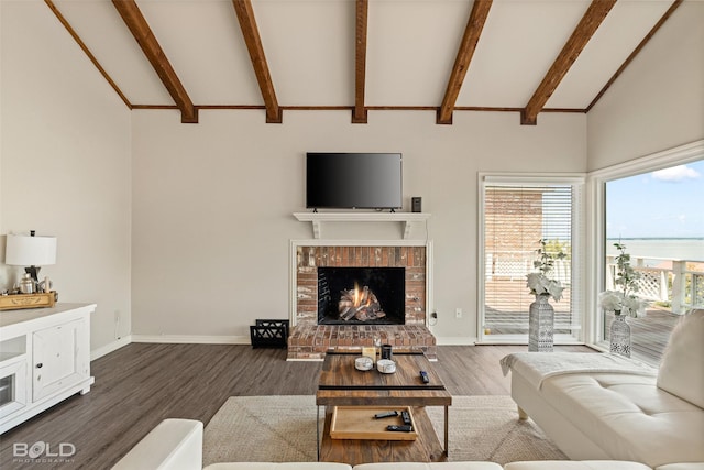 living room with vaulted ceiling with beams, a fireplace, and dark hardwood / wood-style flooring