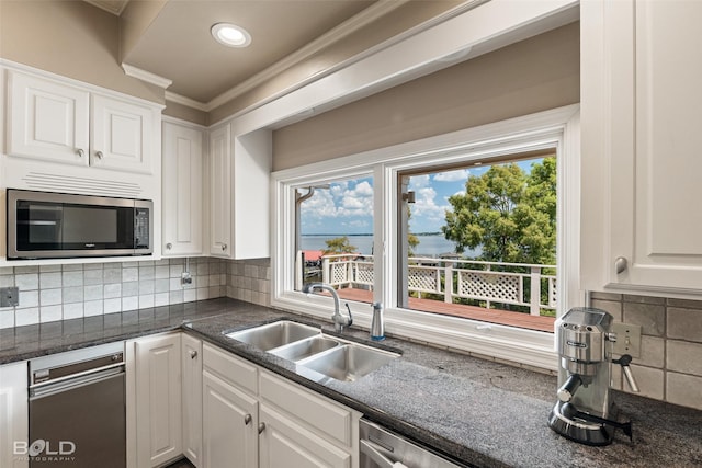 kitchen featuring sink, backsplash, white cabinets, and dark stone counters