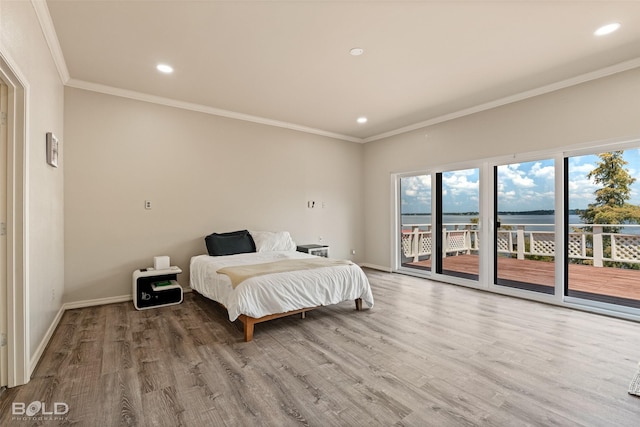 bedroom featuring access to exterior, crown molding, a water view, and hardwood / wood-style flooring