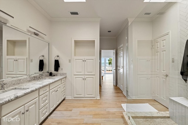 bathroom with vanity, crown molding, and hardwood / wood-style flooring