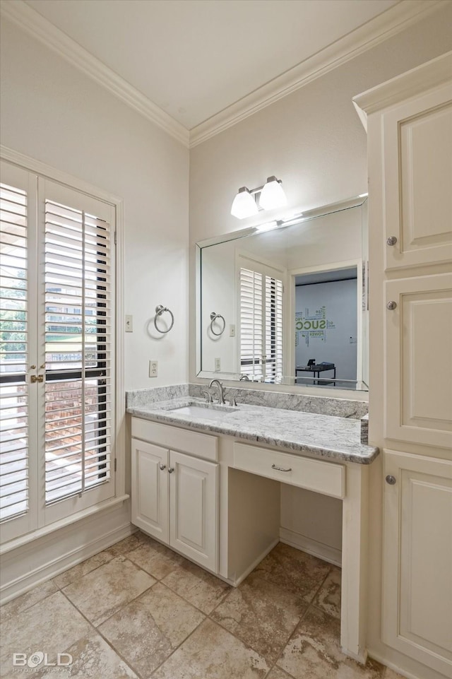 bathroom with a wealth of natural light, vanity, and ornamental molding