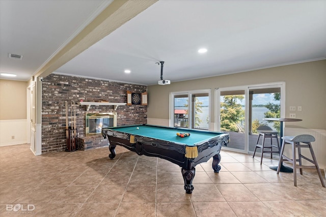 recreation room with billiards, a fireplace, light tile patterned flooring, and crown molding