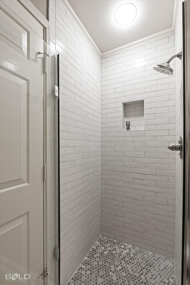 bathroom with ornamental molding and a shower with shower door