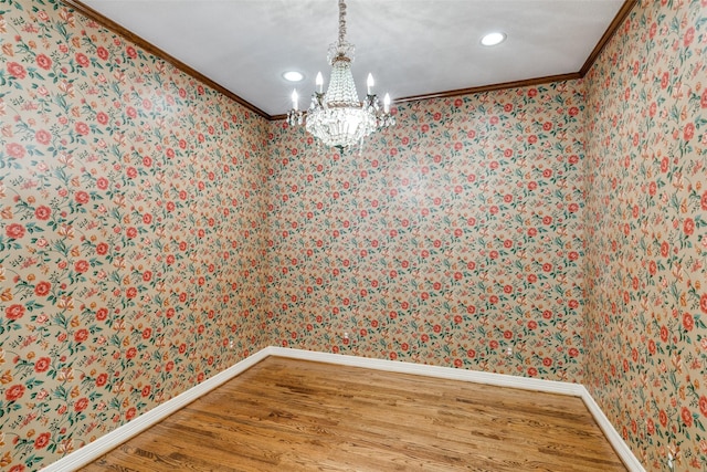 unfurnished dining area with a chandelier, crown molding, and hardwood / wood-style flooring