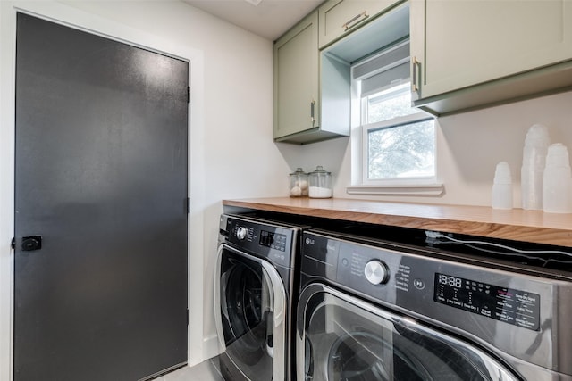 clothes washing area with cabinets and separate washer and dryer