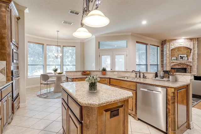 kitchen with sink, a center island, decorative light fixtures, stainless steel appliances, and ornamental molding