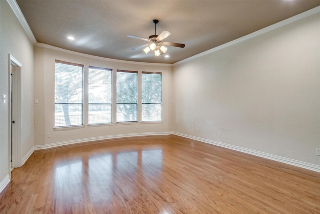 empty room with ceiling fan, ornamental molding, and light hardwood / wood-style flooring