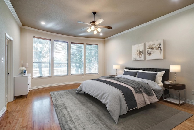 bedroom featuring light wood-type flooring, crown molding, and ceiling fan